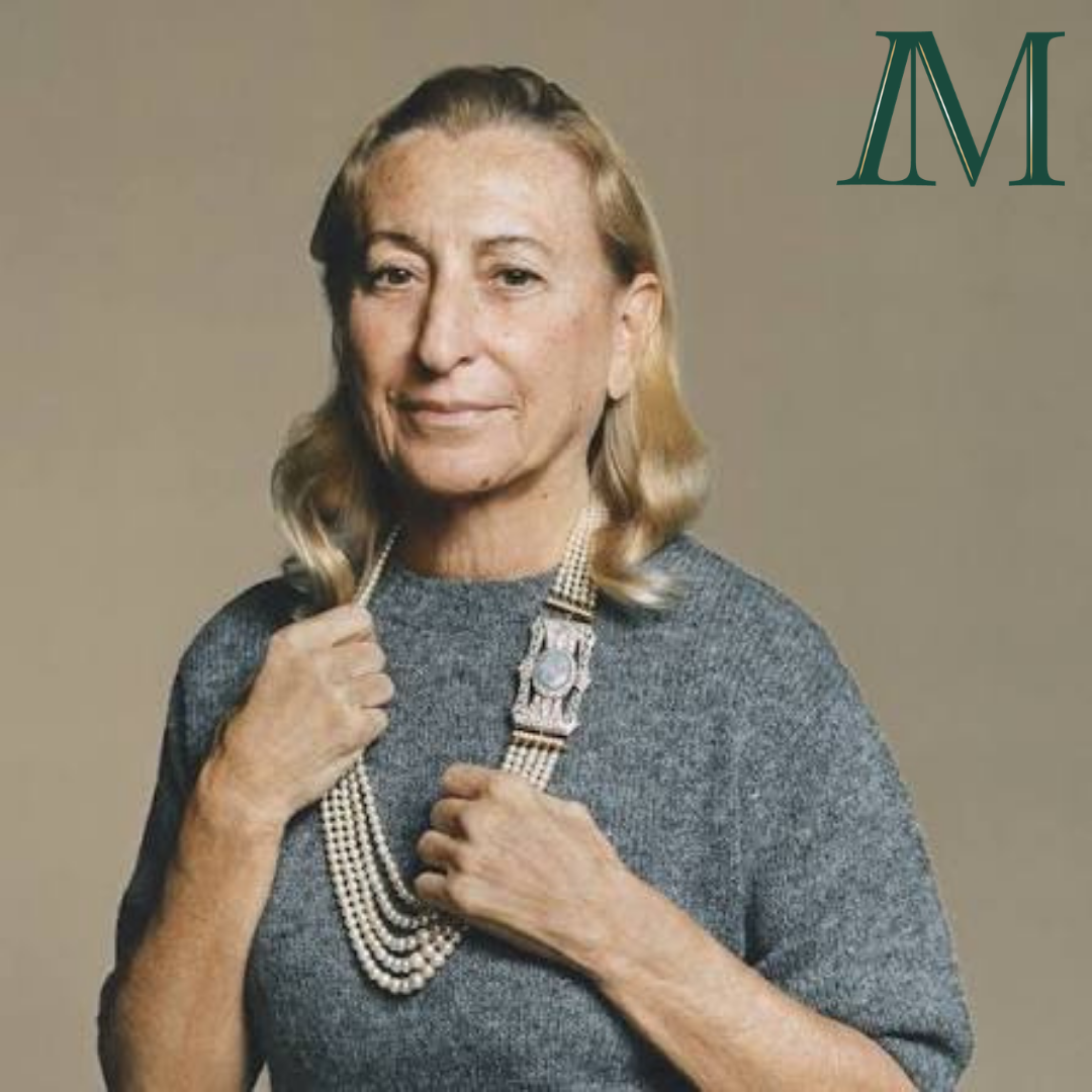 Miuccia Prada, a blonde, caucasian woman in a grey sweater looks directly at the camera, clutching her necklace. The Inspired Method logo is in the top right corner.