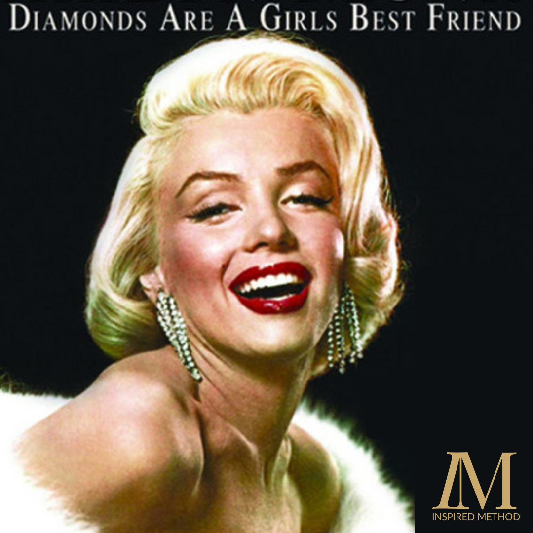 Marilyn Monroe, with her blonde hair and open smile looks directly at the camera, a white fur around her bare shoulders and diamond drop earrings feature heavily in the image. Set against a black background, text appears above her head saying "Diamonds are a girls best friend". The Inspired Method logo appears in the bottom right corner of the image.